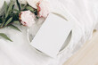 © tabitazn - Wedding still life scene. White empty book cover mockup on marble tray. Pink peony flowers on white linen table cloth. Vintage feminine styled photo, wooden floor. Flat lay. Blurred background.