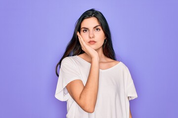 Poster - Young beautiful brunette woman wearing casual white t-shirt over purple background thinking looking tired and bored with depression problems with crossed arms.