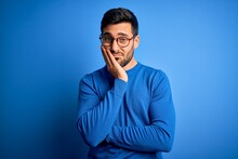 Young Handsome Man With Beard Wearing Casual Sweater And Glasses Over Blue Background Thinking Looking Tired And Bored With Depression Problems With Crossed Arms.