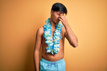 Poster - Young handsome tourist man on vacation wearing swimwear and hawaiian lei flowers tired rubbing nose and eyes feeling fatigue and headache. Stress and frustration concept.