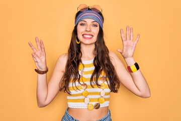 Wall Mural - Young beautiful hippie woman with blue eyes wearing accesories and sunnglasses showing and pointing up with fingers number eight while smiling confident and happy.