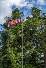 US Flag Unfurled On Windy Day With Blue Sky And Clouds