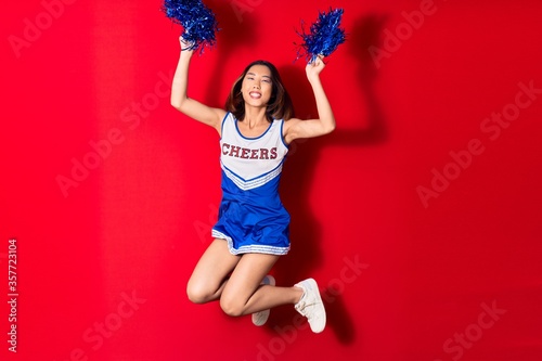 Cuadros en Lienzo Young beautiful chinese girl smiling happy wearing cheerleader uniform