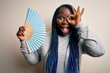 Sticker - Young african american plus size woman with braids using hand fan over white background with happy face smiling doing ok sign with hand on eye looking through fingers