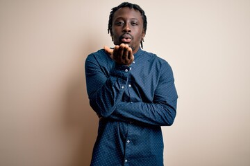 Poster - Young handsome african american man wearing casual shirt standing over white background looking at the camera blowing a kiss with hand on air being lovely and sexy. Love expression.