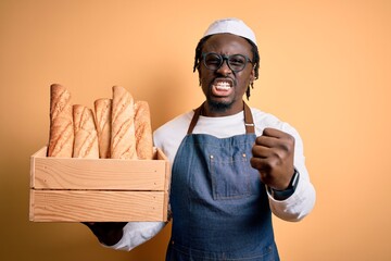 Sticker - Young african american baker man wearing apron holding wooden box with homemade bread annoyed and frustrated shouting with anger, crazy and yelling with raised hand, anger concept