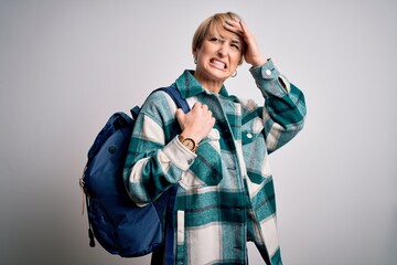 Sticker - Young blonde woman with short hair wearing travel backpack over isolated background stressed with hand on head, shocked with shame and surprise face, angry and frustrated. Fear and upset for mistake.