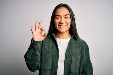 Sticker - Young beautiful asian woman wearing casual shirt standing over isolated white background smiling positive doing ok sign with hand and fingers. Successful expression.