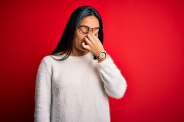 Canvas Print - Young beautiful asian woman wearing casual sweater and glasses over red background tired rubbing nose and eyes feeling fatigue and headache. Stress and frustration concept.