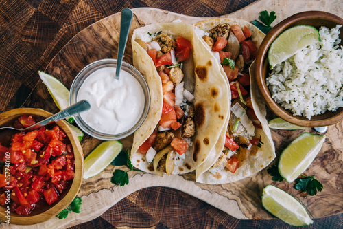 Fotomural An olive board filled with delicious Mexican fiesta of food tacos and burritos w