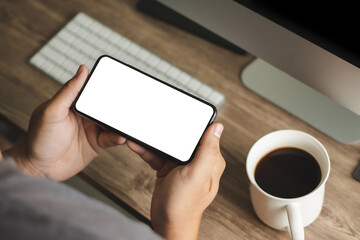 Wall Mural - Top view Mockup image hand using a smartphone man Holding Cell Phone With Blank Screen