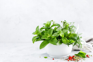 Wall Mural - Bunch of aromatic herbs in mortar on kitchen table