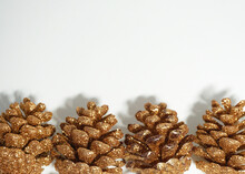 Gold Pine Cones On White Background. Christmas Concept.