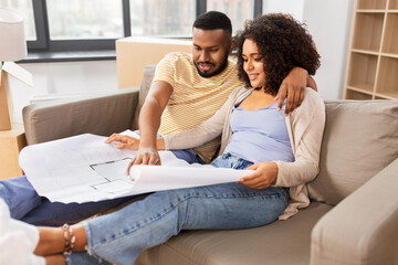 Wall Mural - mortgage, people and real estate concept - happy african american couple with boxes and blueprint moving to new home