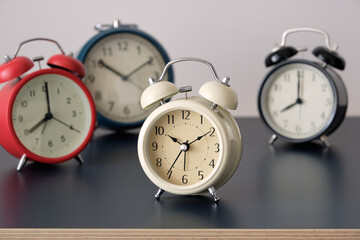 Wall Mural - Many alarm clock with different color on dark table and white background.