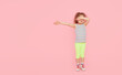 © oes - Challenges for children. Child girl model in full growth on a pink studio background. empty space for inscription