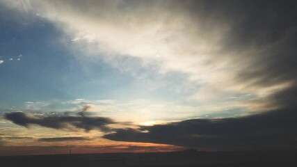 Wall Mural - Timelapse of sunset in the cloudy sky above the city. Taken on an iPhone