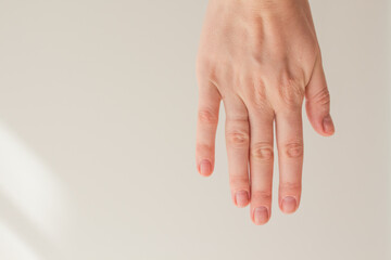  Female hand with natural manicure without gel polish on a white background with space for text. Hand energy