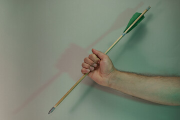 Poster - Hand holding old green arrows in the color light. Beautiful old arrow minimal in neon light. Minimalism retro style concept. Background pattern for design.