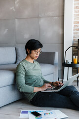 Sticker - Image of asian man working with laptop and documents while sitting