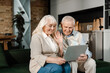 © LIGHTFIELD STUDIOS - happy senior couple waving and having video chat on laptop at home during self isolation
