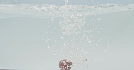 Wall Mural - Ripe sweet cherry falls into the water on a clean white background with a splash. Bubbles of air in the water. Slow motion. Video shooting under water. Full HD video, 240fps,1080p