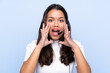 © luismolinero - Young telemarketer Colombian woman over isolated blue background shouting with mouth wide open