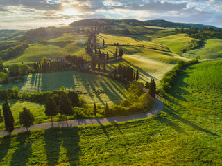 amazing colorful sunset in tuscany. picturesque agrotourism and typical curved road with cypress, la