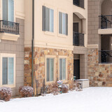 Fototapeta Do pokoju - Square Residential apartment building facade with snow covered yard in winter
