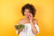 © Jihan - Lifestyle Concept - Portrait of beautiful Caucasian joyful woman holding a salad talking on mobile phone with friend. Yellow pastel studio background. Copy Space.