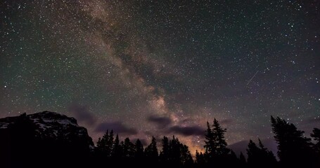 Wall Mural - Time lapse shot of Milky Way over mountain and trees against sky at night - Banff, Canada