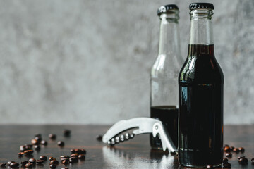 Sticker - selective focus of cold brew coffee in bottles near opener and coffee beans