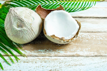 two coconut and coconut leaves on wooden table