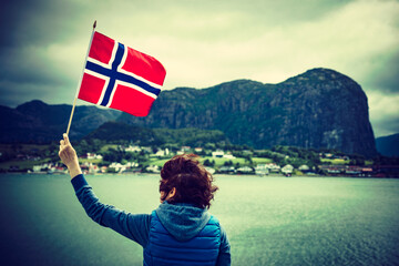 Wall Mural - Tourist with norwegian flag on fjord