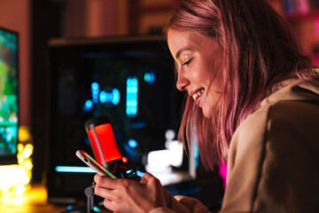 Poster - Image of girl using cellphone and smiling while playing video game