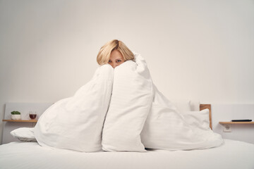 Woman burying her face in a blanket