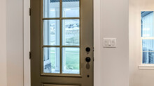 Panorama Hinged Front Door With Glass Pane Viewed From Interior Of Home With Wood Floor