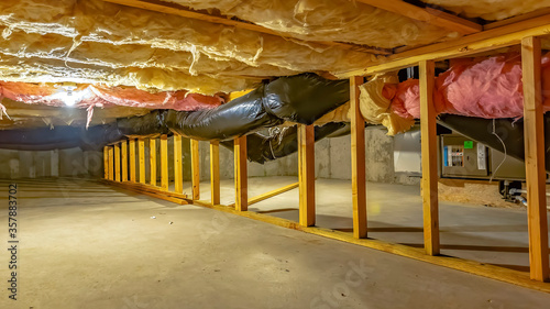 Panorama Basement or crawl space with upper floor insulation and wooden support beams