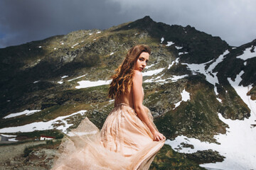 Wall Mural - beautiful young girl in long dress at the mountains