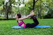 © anusak - woman doing a yoga pose on a garden in morning