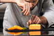 © stockbusters - Chef male decorate cake at kitchen. Close up chef hands make orange cake.