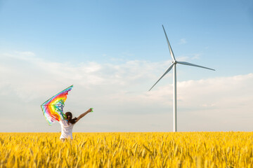 little girl runs in a wheat field with a kite