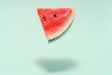 Watermelon Slice Falling On Pastel Background. Floating Fruits In The Air. Flying Red Fruits. Summer Background. Trend Colors, Copy Space.