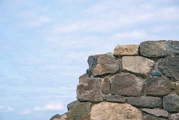 Fragments of old buildings against the backdrop of a cloudy summer sky and sea.