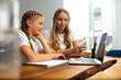 © Yakobchuk Olena - Loving mother helping daughter to do homework online