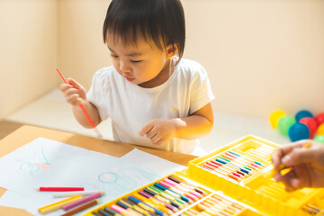 Cute asian little girl is painting the color with fully happiness moment , concept of art and education for kid. closed up kid practice paiting for homeschooling.Lovely asian girl drawing