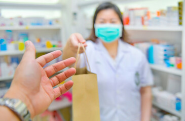 Customers are receiving medication bags in the Pharmacy store.