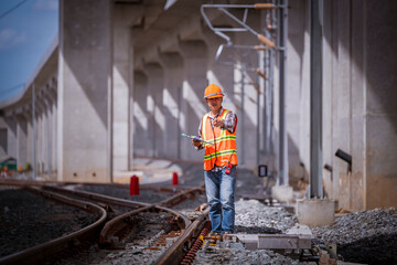 Wall Mural - Engineer under inspection and checking construction process railway switch and checking work on railroad station .Engineer wearing safety uniform and safety helmet in work.