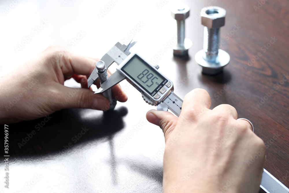 Worker is measuring to the diameter of the small pipe with a digital ...