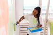 © satura_ - Happy African American woman painting wall in her new apartment. Renovation, redecoration and repair concept.